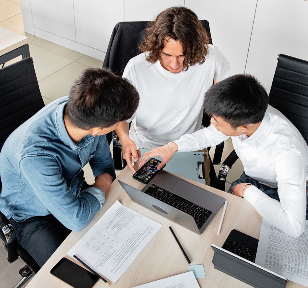 Team working together at a table with laptop and documents
